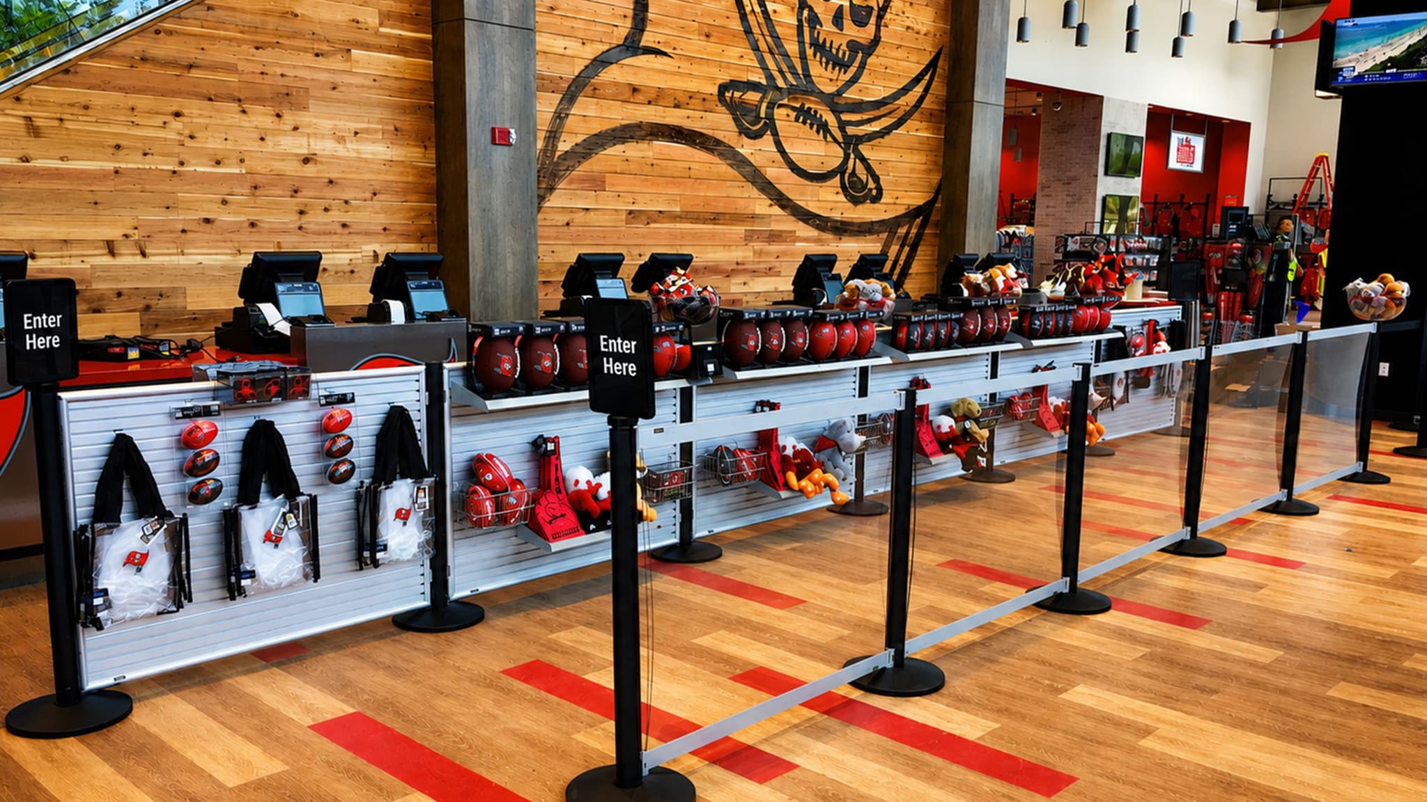 Beltrac retractable belt stanchions and slatwall displays of team gear guide shoppers through the Buccaneers team store checkout.