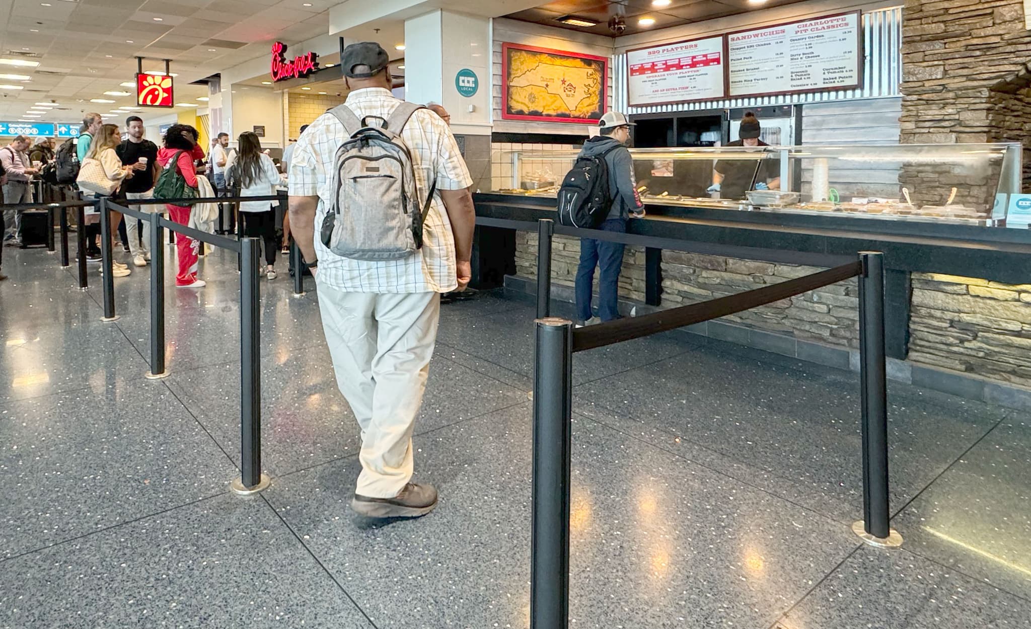 Beltrac retractable belt stanchions guide customers into a Chick-fil-A restaurant inside an airport terminal.