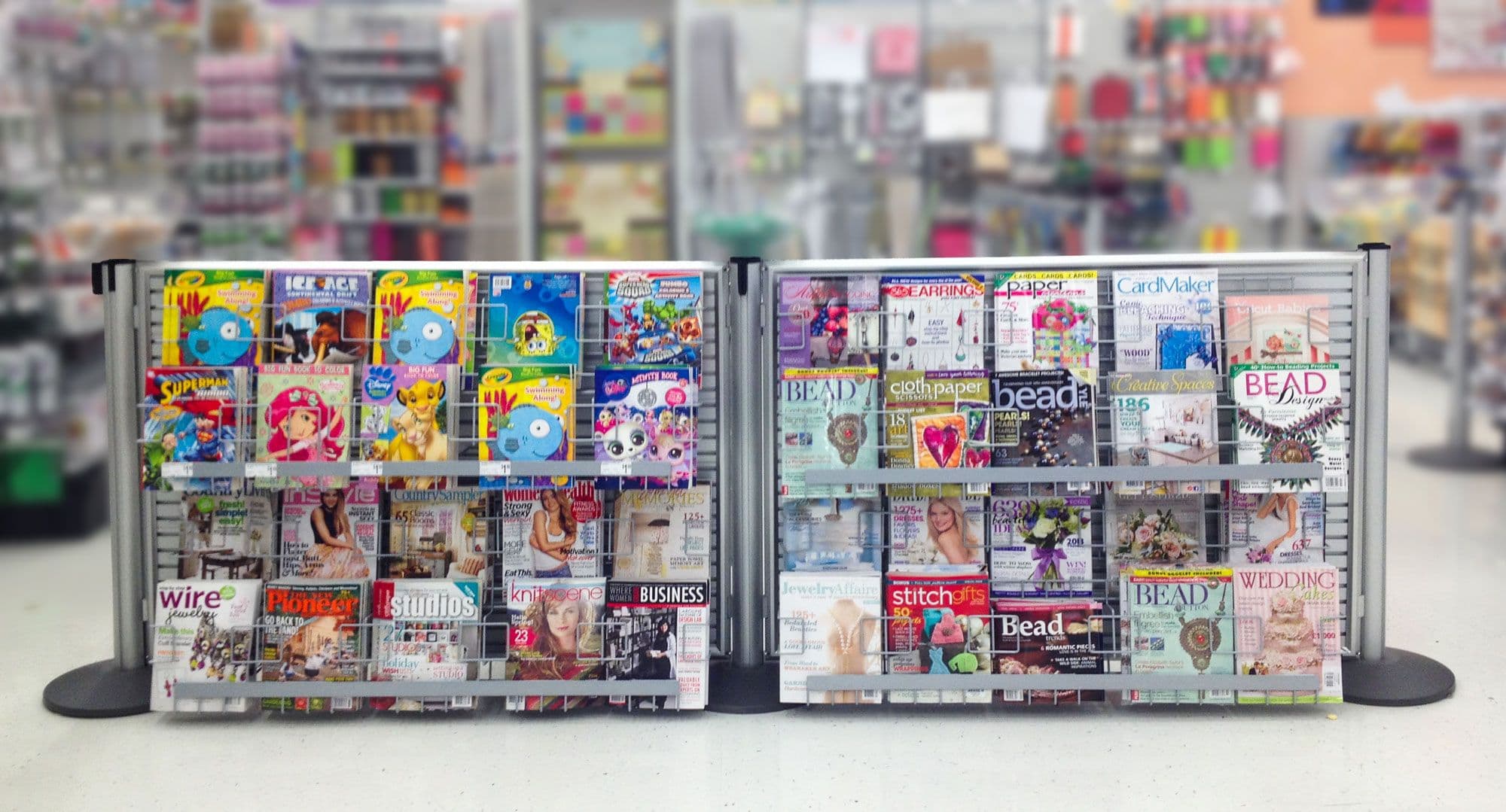 A NeXtrac slatwall magazine rack displays impulse items at the checkout of a Michaels craft store.