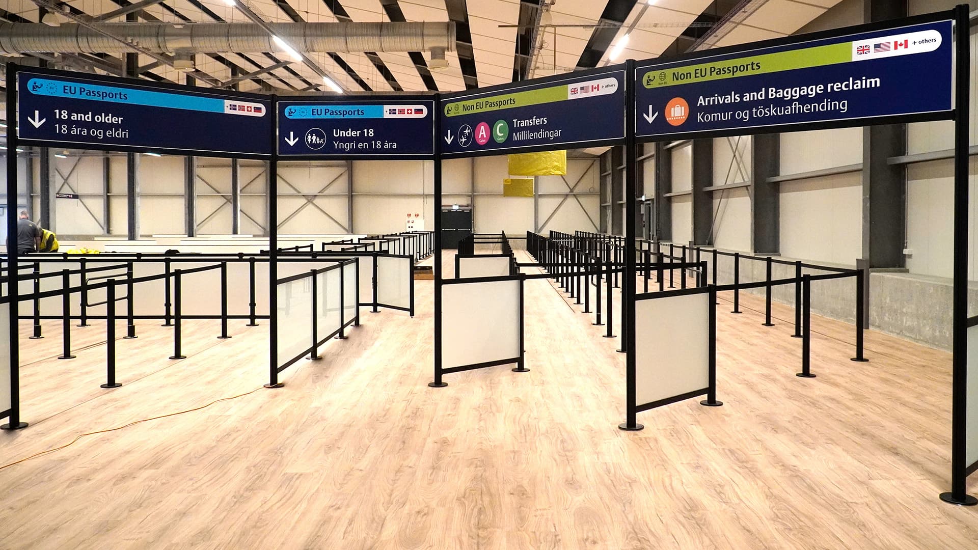 An overhead banner sign on tall partition posts marks the security queue at Keflavik International Airport in Iceland.