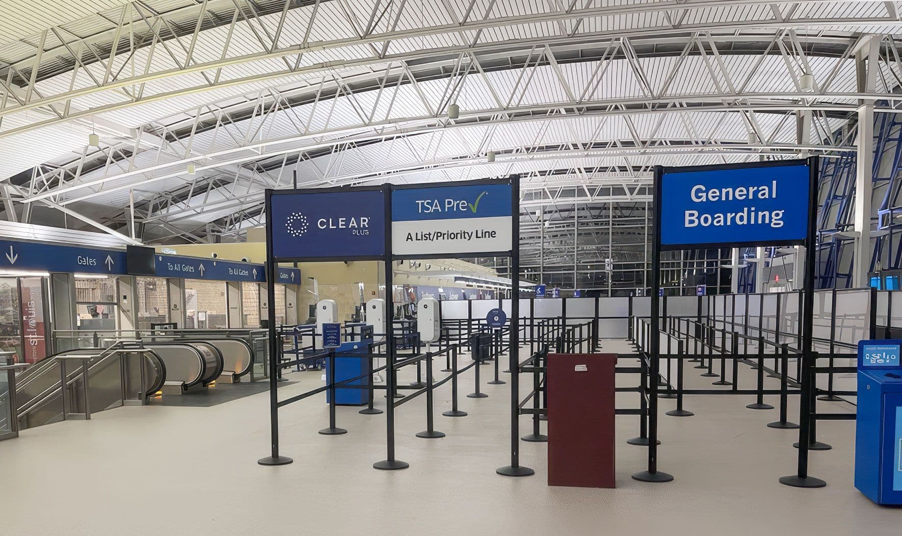 Custom overhead signs on tall partition posts direct passengers at Terminal 2 of St. Louis Lambert International Airport.