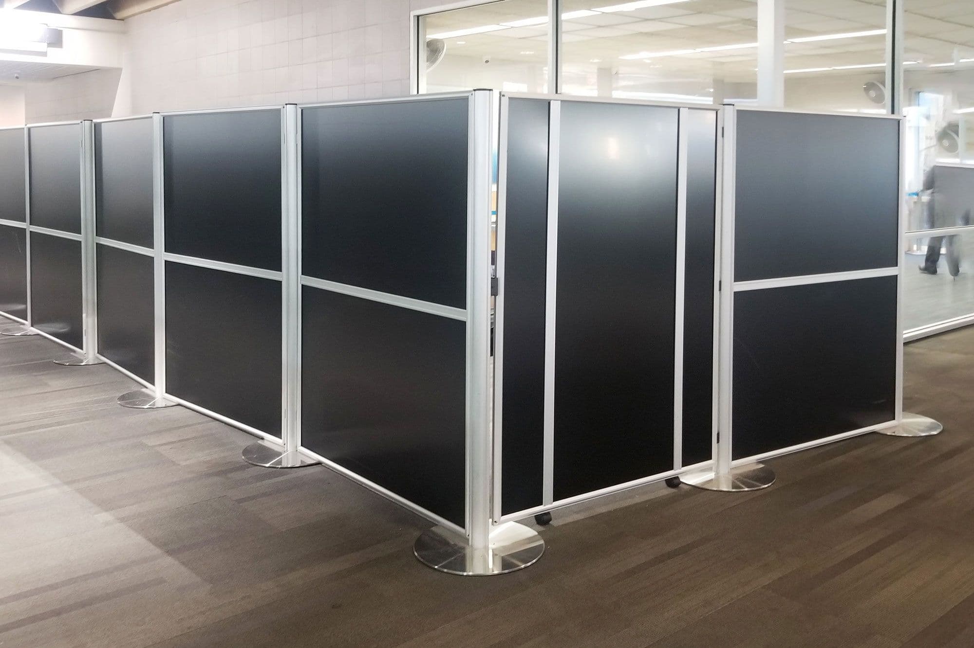 Tall partition posts and panels create a portable privacy room and storage area.