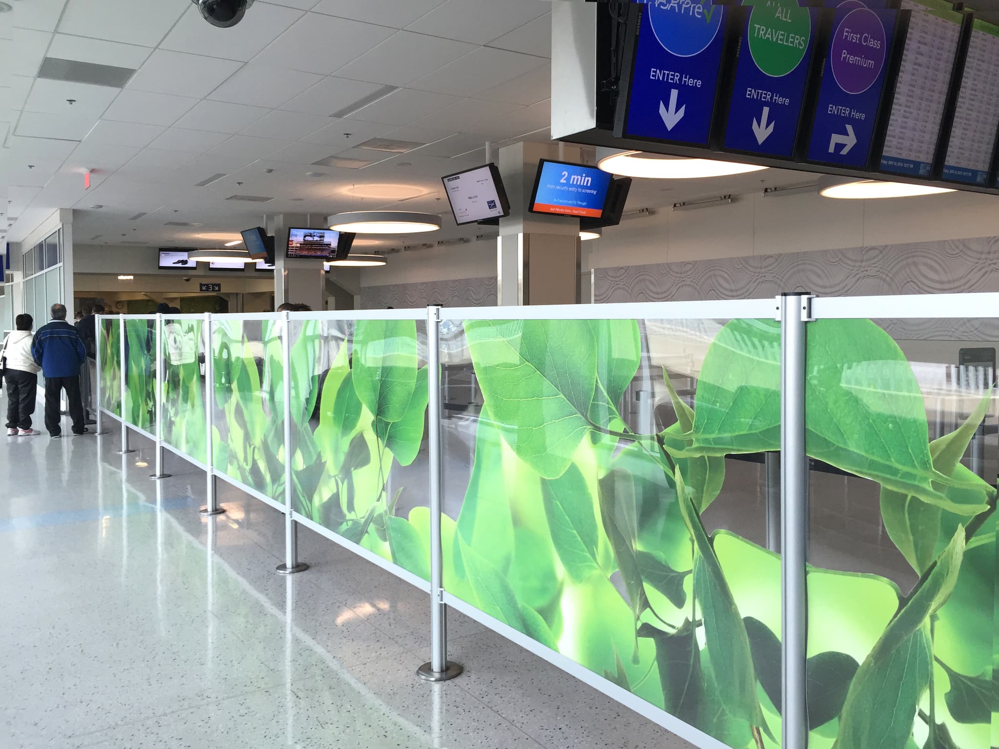 Magnetic partition posts with printed acrylic Rigid Rail panels line the security queue at Dallas Fort Worth International Airport.