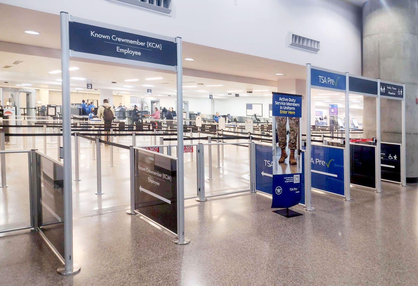 Overhead signs on tall partition posts direct passengers into the security queue at Tucson International Airport.