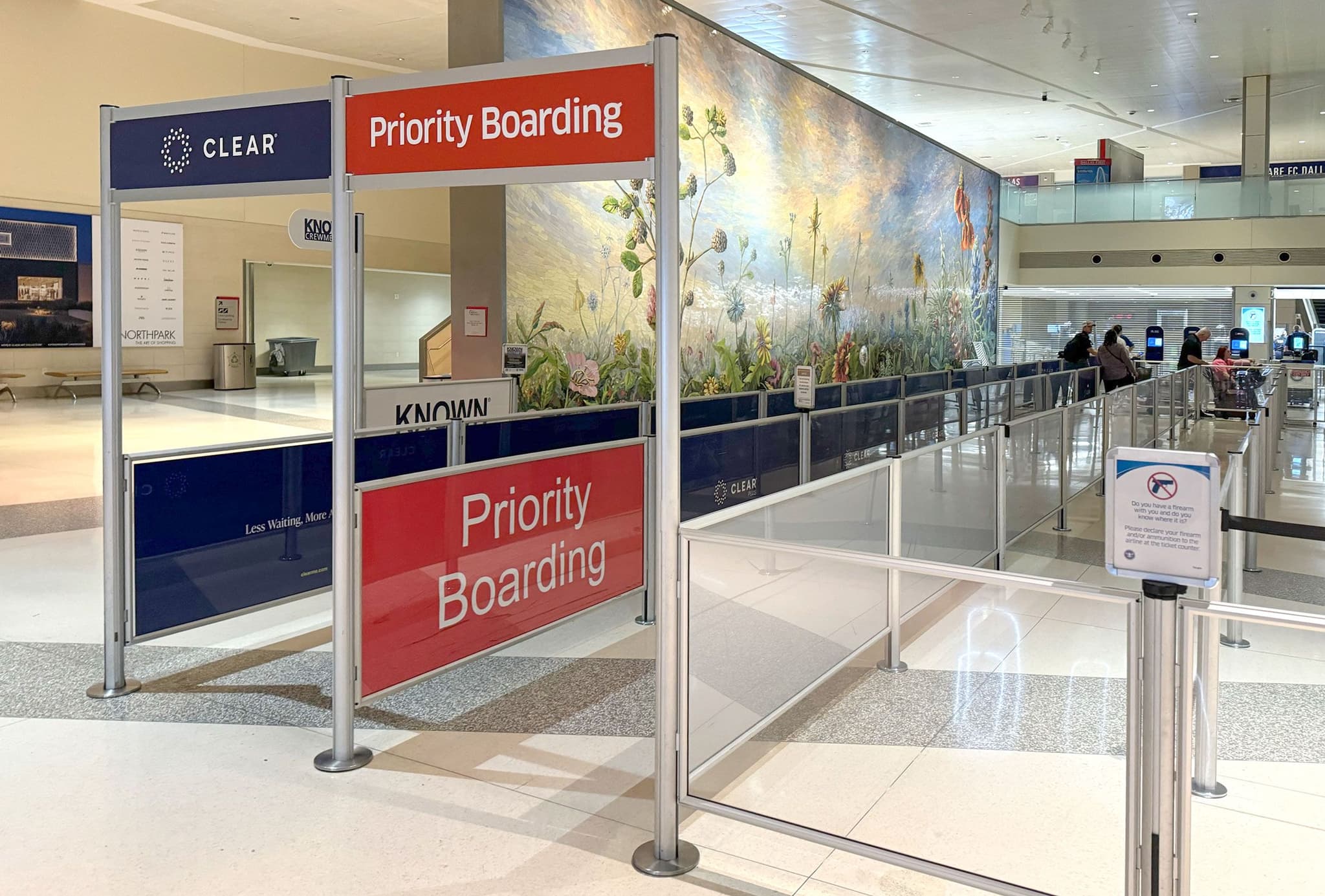 Rigid Rail barriers with printed priority boarding signage organize the security queue at Dallas Love Field Airport.