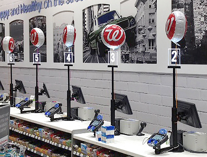 An unattended row of cashier stations, with register lights, at Walgreens.